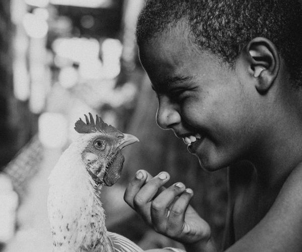 A child laughing while trying a playful animal yoga pose.
