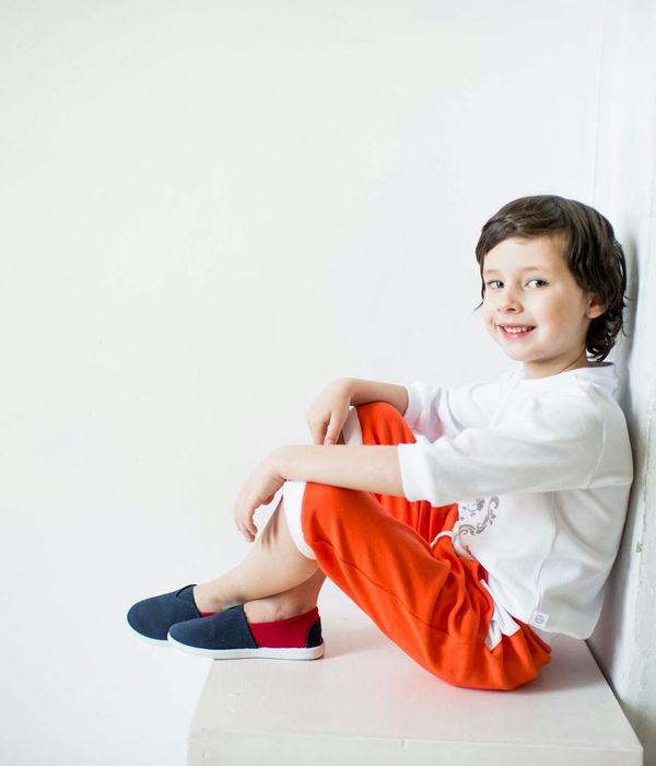 Happy children doing a simple yoga pose in a bright room.